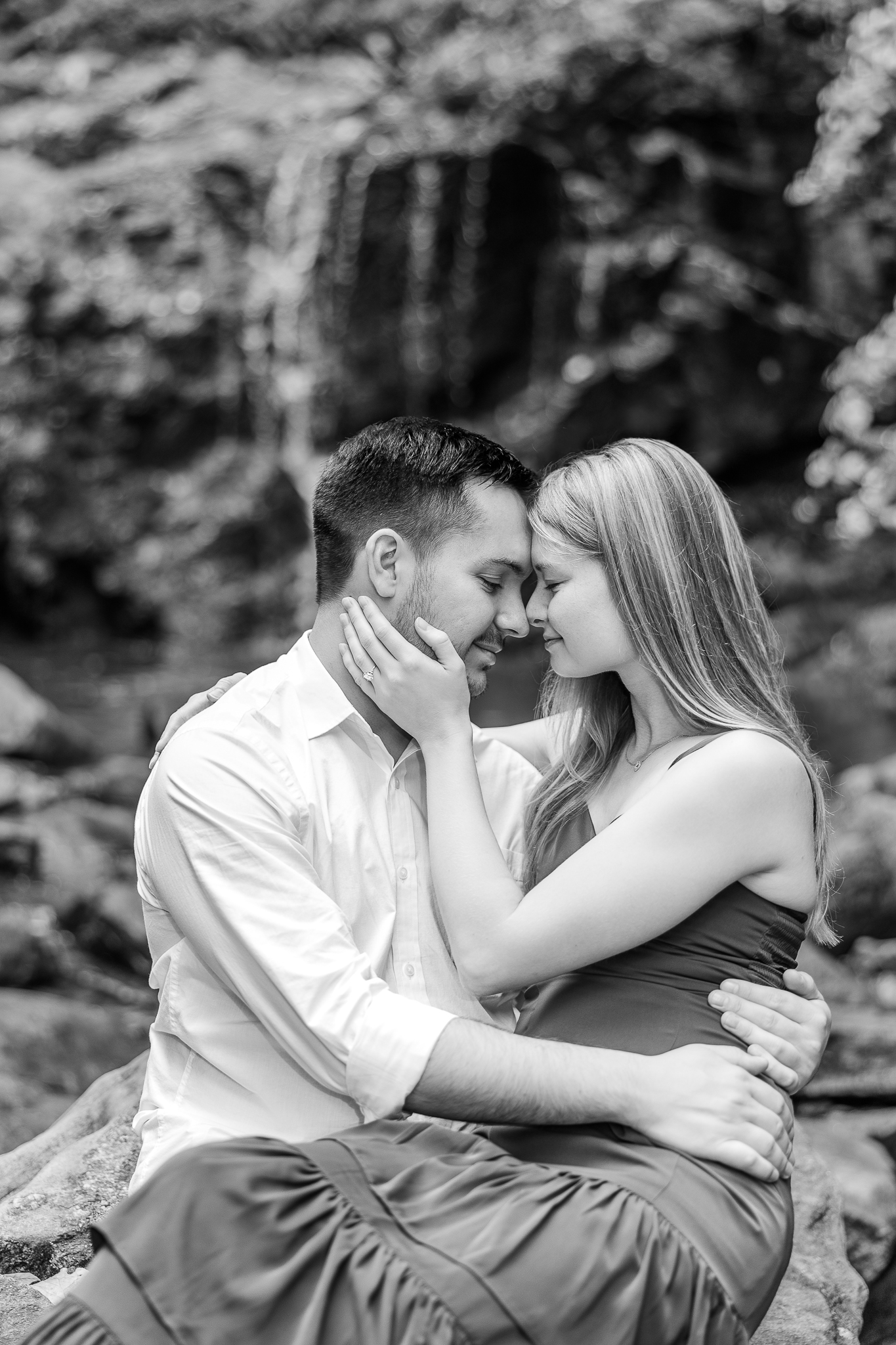 A couple is nose-to-nose in front of a waterfall at Patapsco Valley State Park